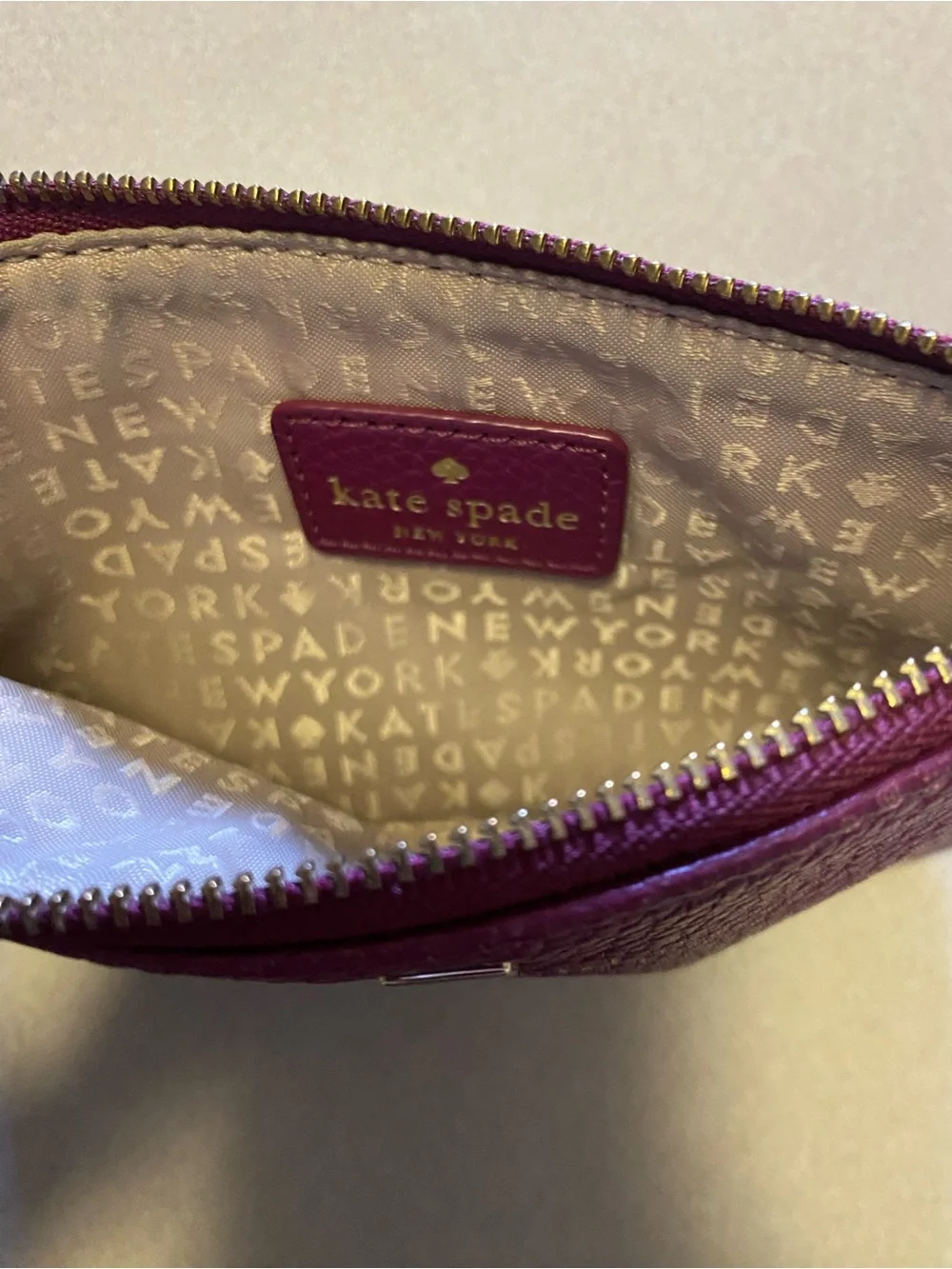 kate spade plum pebbled leather wristlet with gold logo